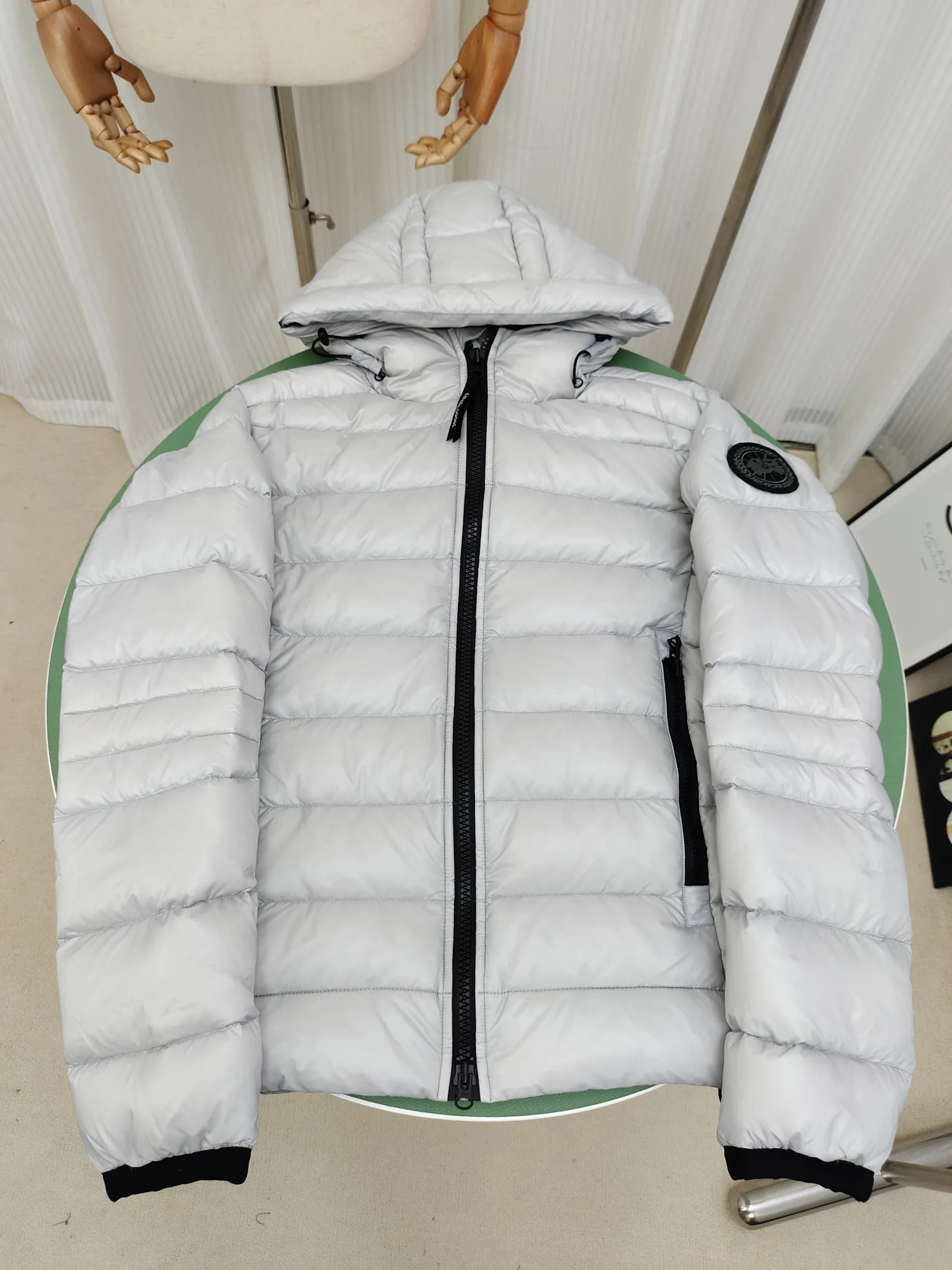 P860 ————2227MB model (high version) Canada goose Crofton hooded down jacket, this is a down jacket suitable for late autumn and early winter: on cold, rainy mornings, it can be used as a layer of warmth inside the rainproof jacket, and can be worn alone in the late autumn and early winter with a little bit of coolness. Filled with white duck down. The Crofton Hooded Jacket is a versatile, lightweight and versatile piece that even packs itself in for easy transport. The inner layer has removable elastic straps, making the jacket easy to carry on the shoulder and hands-free. 2 zippered hand pockets with fleece fabric on the knuckle side for softness and warmth. Color: black with black label, black with red label, ocean blue, superoxide blue, silver birch red label, silver birch black label Size: XS-2XL
